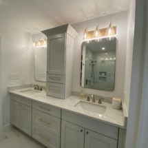 Icy Avalanche cabinets with gold pulls, crystal knobs, and gold light fixtures