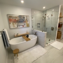 Freestanding tub beside white shower